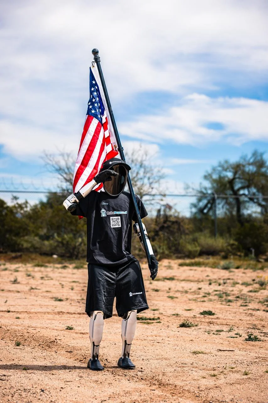 Gary the humanoid robot holding an American flag outdoors